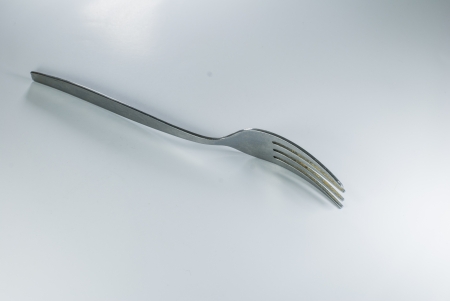 silver spoon and fork in shallow focus close up - isolated on white backgroundの写真素材