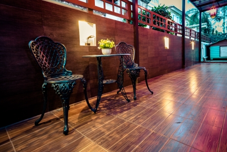 couple steel chair and table with yellow flower and beautiful light bulb in the houseの写真素材