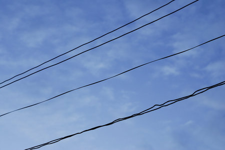 lines in field against a blue sky - messy electrical lines