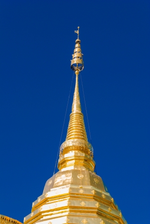 Top of yellow pagoda against blue clear skyの写真素材