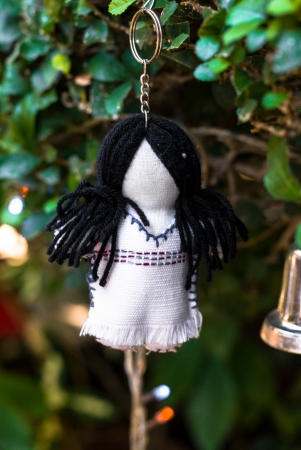 A girl doll decoration hangs on a branch of a treeの写真素材