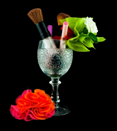 Wine crystal glass with brushes and makeup cosmetics isolated on black - set of cosmetics in crystal glassの写真素材