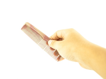 brown comb in hand isolated on white background - hand holding combの写真素材