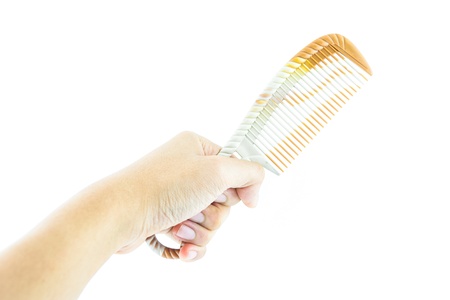 brown comb in hand isolated on whiteの写真素材