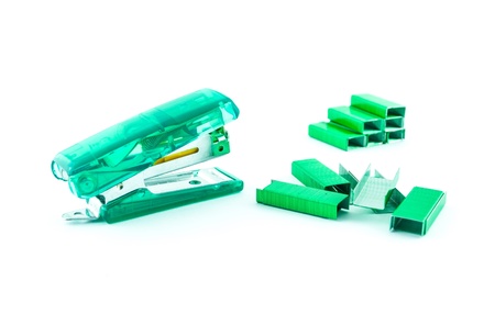 Green stapler and bunch of staples isolated on whiteの写真素材