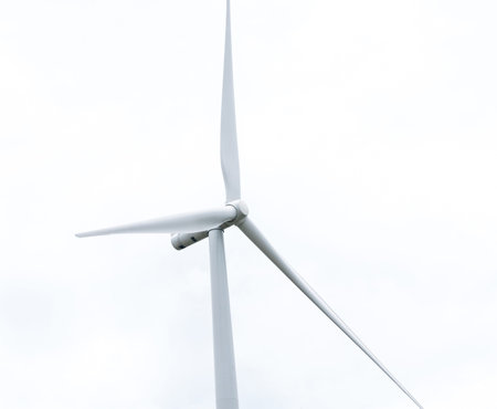wind turbine in wind farm against cloudy sky