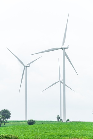 Eco power, wind turbines against very cloudy on green fieldの写真素材