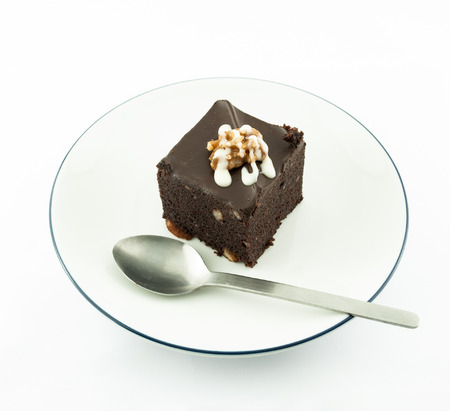 Piece of dark chocolate cake isolated on white plateの写真素材