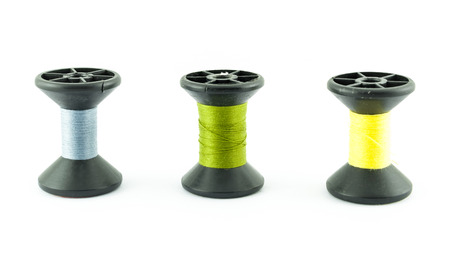 colored bobbins of silk threads on a coils isolated on whiteの写真素材