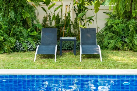 View of black long chairs set aside swimming-poolの写真素材