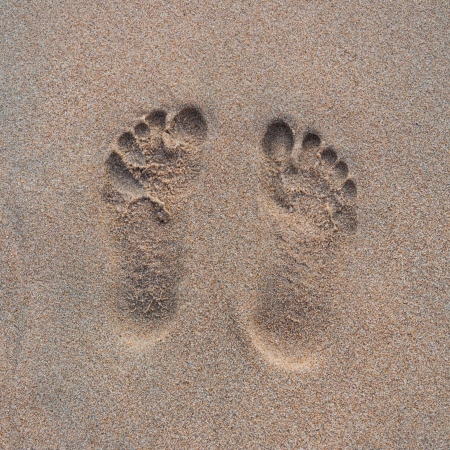 Two human Footprints in sand at the Beachの写真素材