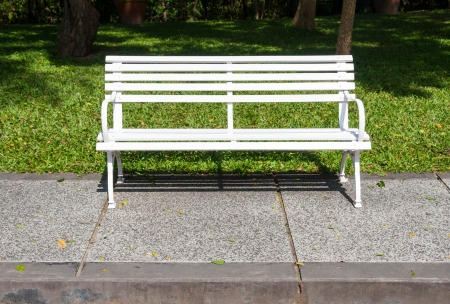 White bench in lush garden or parkの写真素材