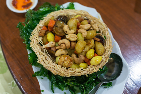 Stir cashews, five fruits, vegetables put in fried taro bowlの写真素材