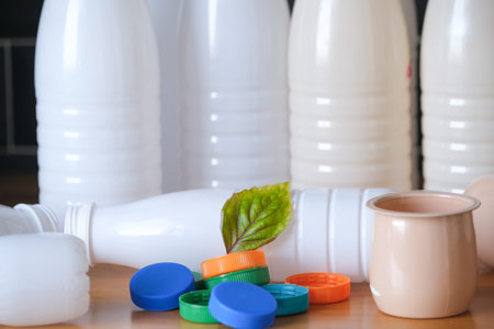green fresh leaf and plastic bottles, lids and food packaging are being prepared for waste sorting