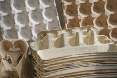many cardboard packs and empty egg carton boxes on a grey wall background, reusable packaging and...