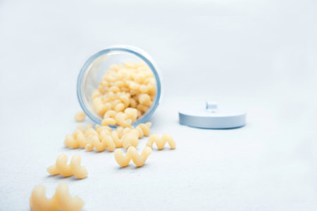 Macaroni in a glass jar on a white background. selective focus.の写真素材