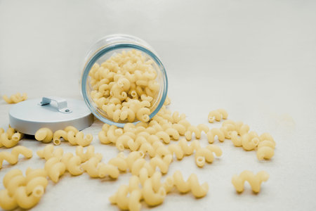 Close up of dry pasta in a jar on a white background.の写真素材