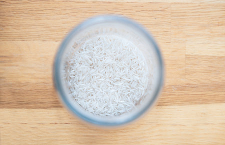 Rice in a glass of water on wooden background, stock photoの写真素材