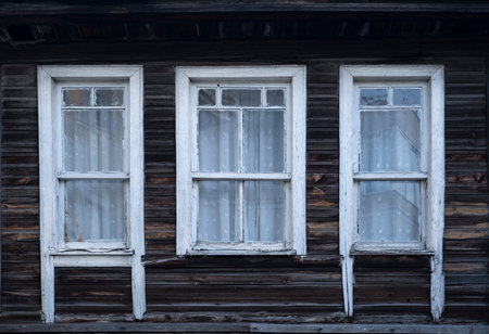 Old wooden windows on the facade of an old wooden house in Russiaの写真素材