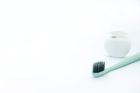 Toothbrush and toothpaste on a white background with copy space