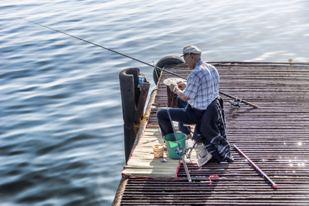 The fisherman's cap on a breakwater in the sea catches.のeditorial素材