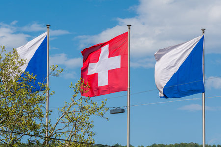 National flag of Switzerland and flag of Zurich city  are waving at the Zurich lake