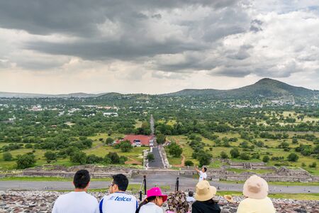 A group of tourists sitting  on the top of the largest ruins of the architecturally significant Mesoamerican pyramids  in Teotihuacan, an ancient Mesoamerican city located in a sub-valley of the Valley of Mexicoのeditorial素材