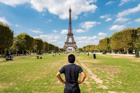 A Chinese tourist looking at the Eiffel Tower , a wrought-iron lattice tower on the Champ de Mars in Paris, France, named after the engineer Gustave Eiffel, constructed from 1887 to 1889.のeditorial素材