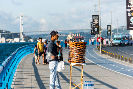 Young Turkish young man seller of Turkish Sesame Bagels at the on the waterfront of Uskudar, Asian...