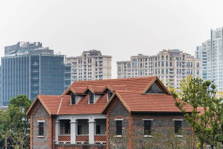 A red tile traditional house and modern skylines in Shanghai, China.のeditorial素材