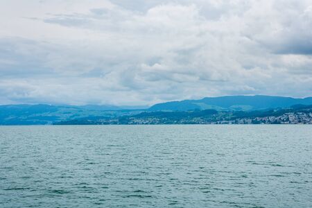 Beautiful lake Zurich landscape. Cloudy skyscape with  background of Alps mountains peaks.の写真素材