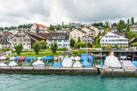 Boats parking on the lake of Zurich, with background of beautiful building on the lakeshore in Zurich, Switzerland.の写真素材