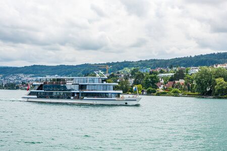 Cruise ship sailing on the lake of Zurich, with background of beautiful building on the lakeshore in Zurich, Switzerland.のeditorial素材