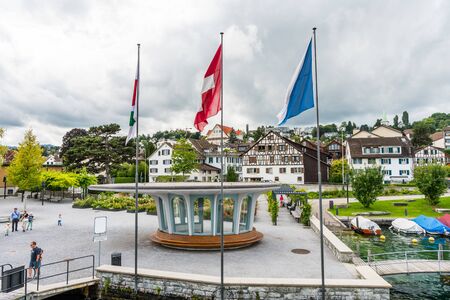 Flags of Zurich city and Switzerland at the cruise ship dock at the Lake of Zurich with background of buldings at the lakeshore in Zurich, Switzerland.のeditorial素材