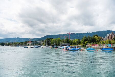 Boats parking on the lake of Zurich, with background of beautiful building on the lakeshore in Zurich, Switzerland.のeditorial素材