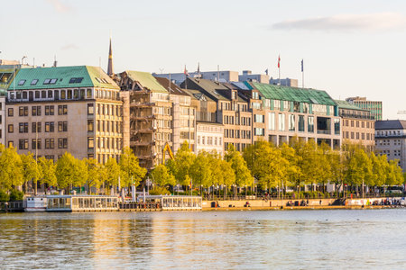 Beautiful building at the bank of Alster Lake with cloudy sky under sunset in Hamburg, Germany.