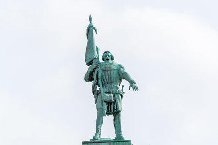A bronze statue of a man holding a flag in the downtown of Stockholm, Sweden.のeditorial素材