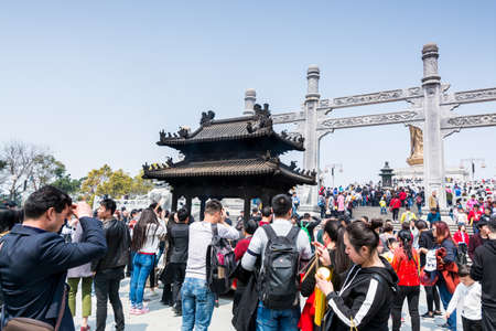 Pilgrim burning incense and praying at Mount Luojia, which lies in the Lotus Sea to the southeast of Putuo Mountain, Zhoushan, Zhejiang, the place where Bodhisattva Guanyin practiced Buddhismのeditorial素材