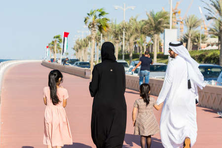 Arabic family wearting traditional drone and walking at the crescent road in the Palm Jumeirah island in Dubai of the United Arab Emirates.のeditorial素材