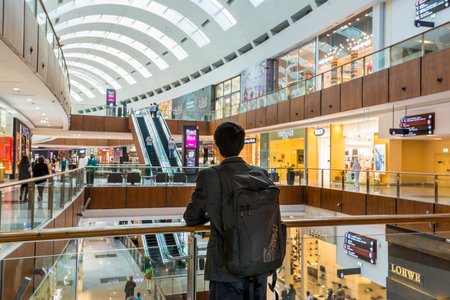 A Chinese male tourist standing in the corridor of Interiors of Dubai mall, one of the world's...