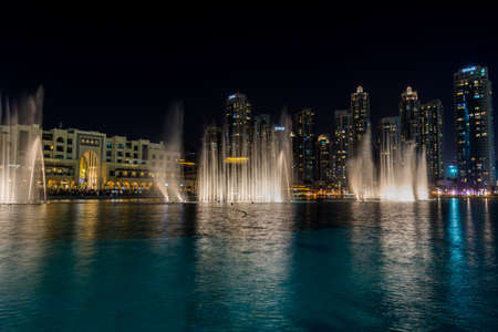Water show in the pool and night view of the skylines near the Burj Khalifa Tower, the tallest building in the world.のeditorial素材