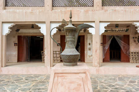 A traditional Arabian copper teapot statue with background of souvenir shops in the Heritage villages in Abu Dhabi, United Arab Emiratesのeditorial素材