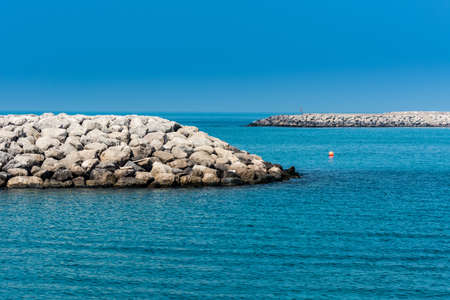 Blue sea and stone dam in the Persian Gulf in the Corniche park in the Abu Dhabi, United Arab...