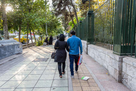 A pair of Iranian couple holding hands and walking in the street of Tehran, Iran.のeditorial素材