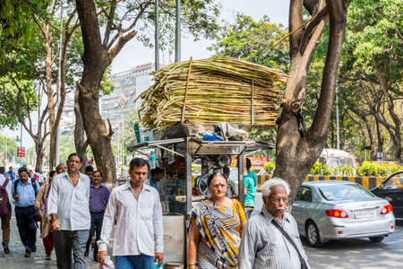 Street view with and Sugarcane juice shop and Pedestrians walking in the street of Mumbai