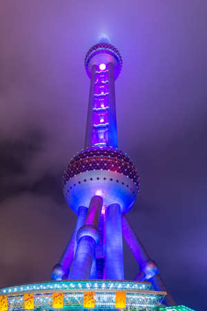 Night view of the The Oriental Pearl Tower at a cloudy day after raining with colorful light in Pudong, Shanghai, China.のeditorial素材