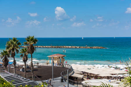 Lots of tourists spending their vacation under the umbrellas at the beautiful beach of Tel Aviv, Israel in summertime.のeditorial素材