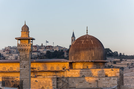 Siliver dome of Al-Aqsa Mosque under sunset in the evening, built on top of the Temple Mount, known as Haram esh-Sharif in Islam and al-Fakhariyya Minaret and wall of old city of Jerusalem, Israel.の写真素材