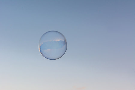 A soap bubble flying in the blue and clean skyの写真素材