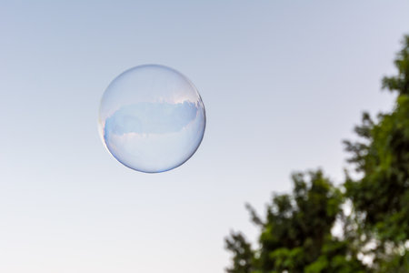 A soap bubble flying in the blue and clean skyの写真素材